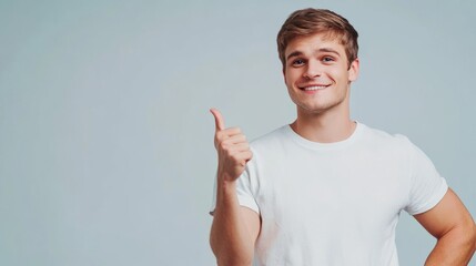 Smiling Young Man Giving Thumbs Up Gesture on Light Background - Positive Expression, Confidence, Success
