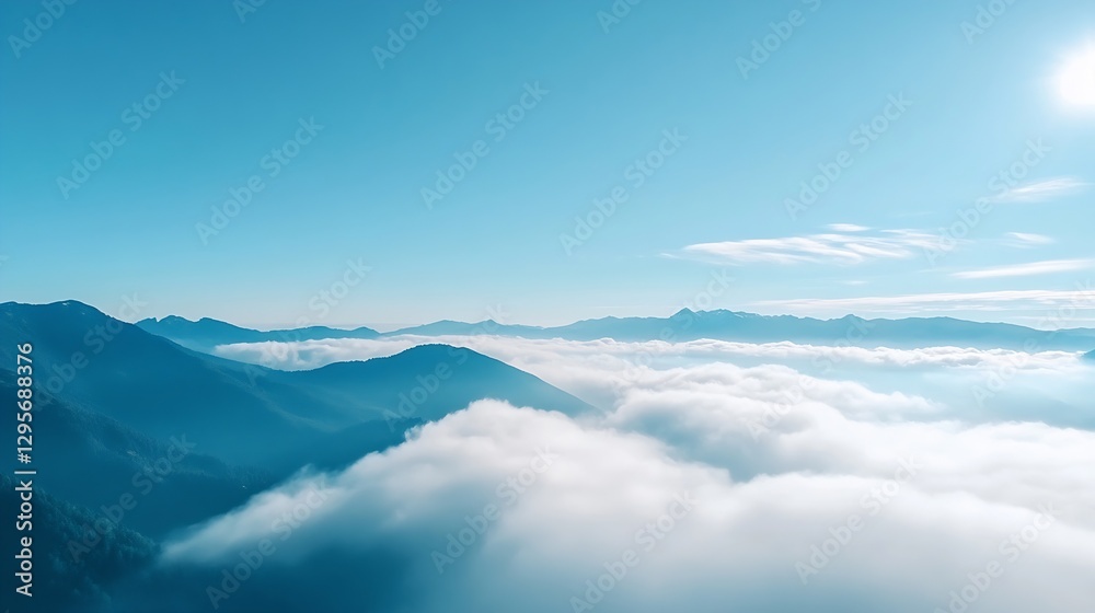Aufkleber breathtaking aerial view of mountains covered in mist and clouds under a clear blue sky during dayti