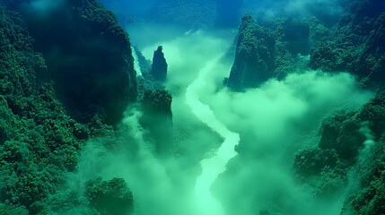 Fototapeta premium Aerial view of a misty river winding through lush green mountains in a serene landscape