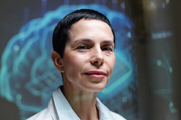 Closeup portrait of smiling mature woman as expert female scientist looking at camera with brain projections in background