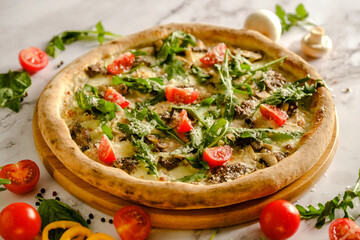 Appetizing, fresh pizza is on the table. Food from an Italian restaurant. Cooking pizza. Pizza ingredients.