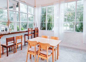 Bright and Airy Modern Dining Room with Large Windows and Minimalist Wooden Furniture in a Sunlit Interior