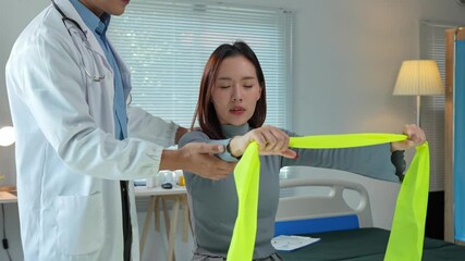Doctor assisting patient with resistance band exercises
