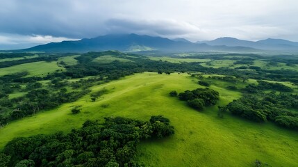 Obraz premium Stunning aerial view of green rolling hills and scenic landscape under a cloudy sky : Generative AI