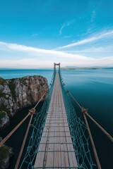Fototapeta premium A stunning rope bridge stretches over serene blue waters, inviting travelers into a peaceful landscape. Perfect for adventure and nature lovers.