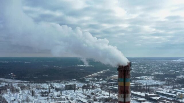 Pollution of the atmosphere by an industrial enterprise of the TPS station. Cloudy day in the winter. Smog smoke carbon and pollution emissions from industry smokestacks.  Cinematic footage