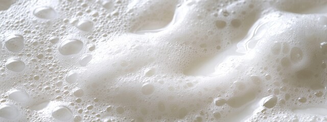 Obraz premium Close-up of Fresh Milk Foam with Bubbles on Surface for Beverage Photography and Culinary Inspiration