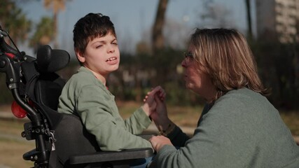 Loving mother caring for disabled son in wheelchair
