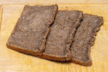 Brotscheiben liegen auf einem Holzbrett, Vollkornbrot, Studio