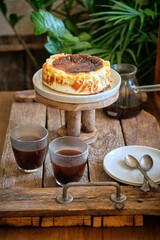 Naklejka premium basque cake with coffee. Wooden background. San Sebastian