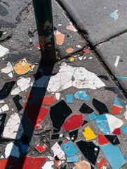 Fototapeta premium Urban Texture: Colorful Paint Splatters by a Pole on Sidewalk