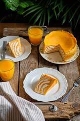 Pumpkin cheesecake. Striped cottage cheese casserole with pumpkin. Side view, wooden background.