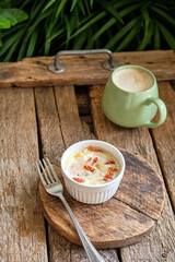 Portion baked eggs with cheese on a board on a wooden table. 
