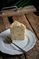 Piece of Napoleon cake. Wooden background, side view.