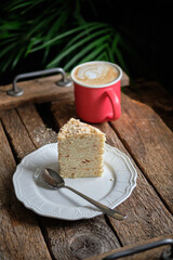 Piece of Napoleon cake. Wooden background, side view.
