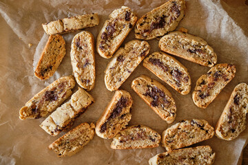 Biscotti with chocolate on a wooden board, top view.