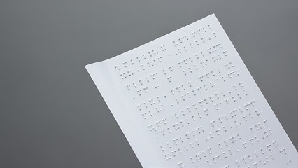 Close up view of braille text on white paper isolated on grey