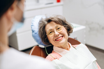 Senior woman smiling while sitting in dentist chair during checkup