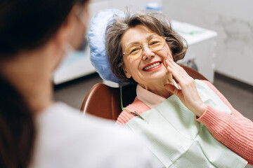 Senior woman touching face after dental checkup at clinic