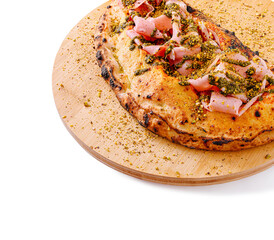 Delicious flatbread topped with ham and pistachios served on wood