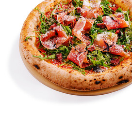 Delicious pizza topped with arugula and prosciutto on a wooden board