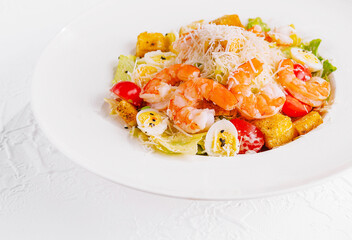 Fresh shrimp caesar salad on white plate
