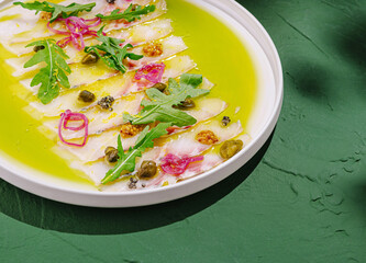 Fresh fish carpaccio served with herbs and condiments in a bowl