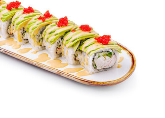 Delicious sushi roll topped with avocado and roe on a white plate