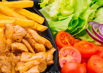 Colorful chicken and salad meal with french fries