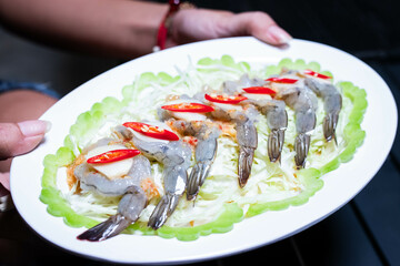 Shrimp soaked in fish sauce spicy in white plate, salty and sour Thai appetizers.