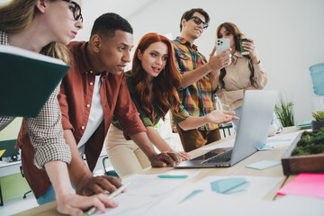 Photo of group young data analytics students at office using computer to find information in internet about their startup fund raising