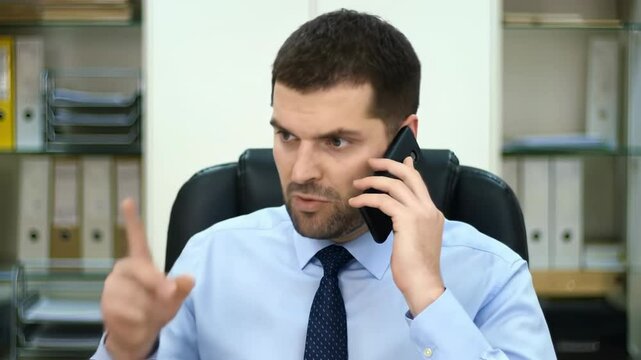Serious businessman on phone call in office, pointing finger with stern expression for leadership and decision-making. Corporate professional, focused communication and authority
