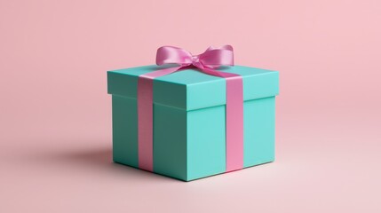 Fototapeta premium A small turquoise gift box tied with a pink ribbon bow