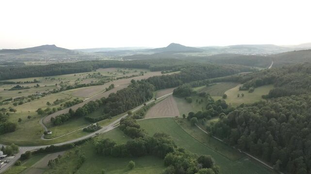 Drone footage capturing the outskirts of Aach village, revealing the peaceful countryside with rolling hills in the background, creating a stunning panoramic view.