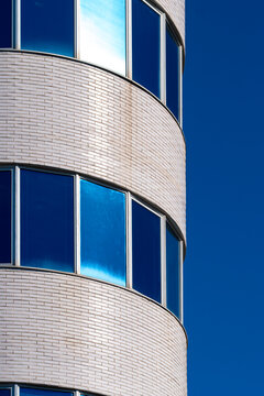 Curved glass tower with seamless reflective surface and modern design.