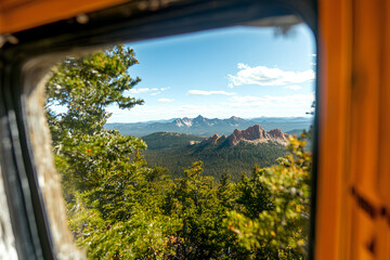 Scenic view from the window of a yellow camper van, overlooking the stunning mountains and natural beauty of Grand Teton National Park