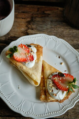 crepes with cream, strawberries and nuts

