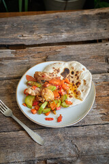 flatbread with zucchini, chicken, carrots and peppers. Wooden background, side view	
