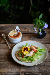 flatbread with lettuce, chicken, hot pepper, nuts and violets. Wooden background, side view	
