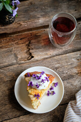 a piece of cake with cream and edible flowers.