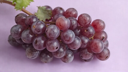 Fototapeta premium A bunch of grapes lies on a light purple background.