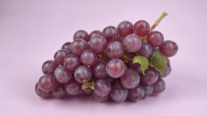 A bunch of grapes lies on a light purple background.