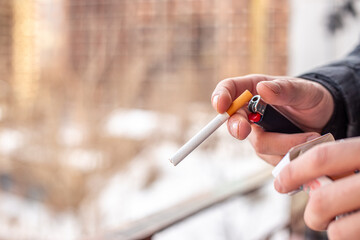 Male hands holding a cigarette and a lighter. Smoking concept.