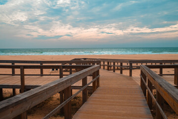Fototapeta premium Ocean Beach in Portugal with Wooden Boardwalks. Scenic wooden pathways stretch along the coastline, inviting peaceful walks and endless exploration