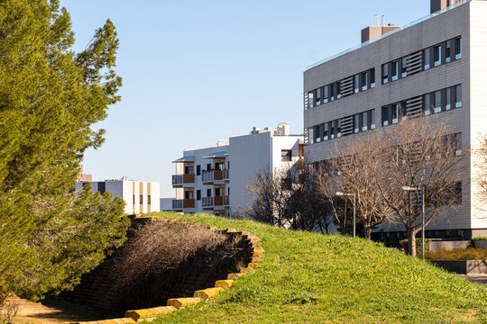 Modern park landscape in Sant Cugat, Barcelona, featuring trees, grass, and urban architecture.