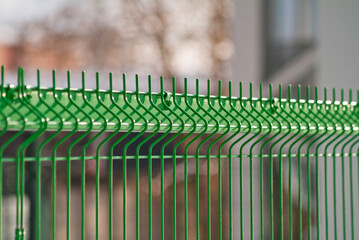 green fence made of 3d mesh panels close-up on gray background