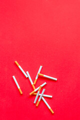 Smoking concept top view. Cigarettes on red background with copy space.