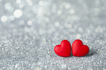 Valentine's day greeting card. Small red hearts on shiny glitter, bokeh effect. Space for text