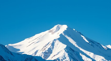 Majestic snow-capped mountain peak against a clear blue sky, showcasing the beauty of winter wilderness and inviting exploration and adventure.  