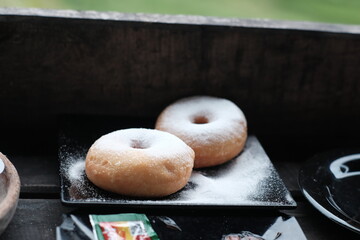 Fresh donuts sprinkled with powdered sugar, perfect for breakfast or a sweet snack.